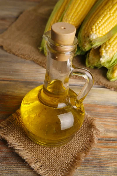 Bottiglia di olio con mais fresco in tavola da vicino — Foto Stock