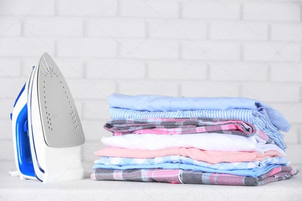 Electronic ironing and pile of clothes