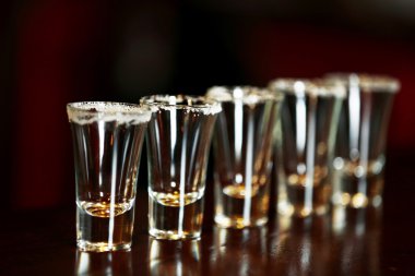 Empty shot glasses on bar counter clipart