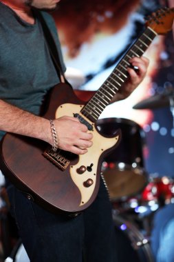Genç adam elektro gitarla oynuyor. Yakın plan.