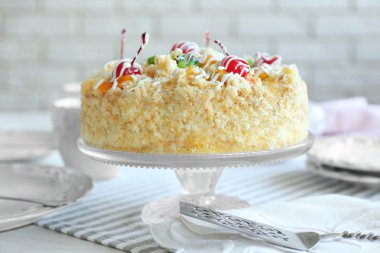 Tereyağı kek kiraz stand ve ışık arka plan üzerinde tablo ayarı ile