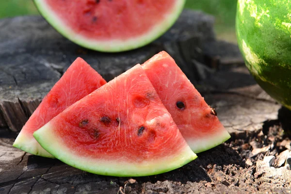 Fresh watermelon on stump of tree, closeup — Stock Photo, Image