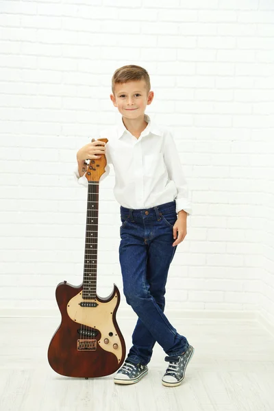 Маленький хлопчик з гітарою на світлому фоні — стокове фото