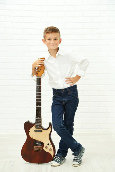 Маленький хлопчик з гітарою на світлому фоні — стокове фото