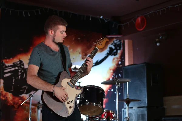 Giovane che suona la chitarra elettrica al pub — Foto Stock