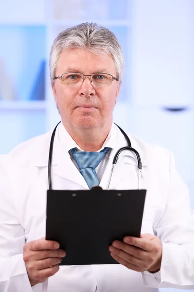 Médecin avec presse-papiers sur le lieu de travail — Photo