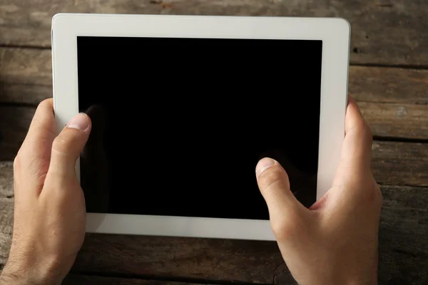 Hands holding digital tablet on wooden table background — Stock Photo, Image