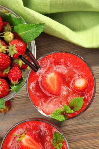 Glasses of strawberry smoothie with berries on table close up — Stock Photo, Image