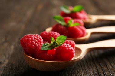 Ahşap masa, tatlı kaşığı taze kırmızı ahududu