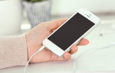 Müzik smartphone içinde el, açık renkli üzerinde