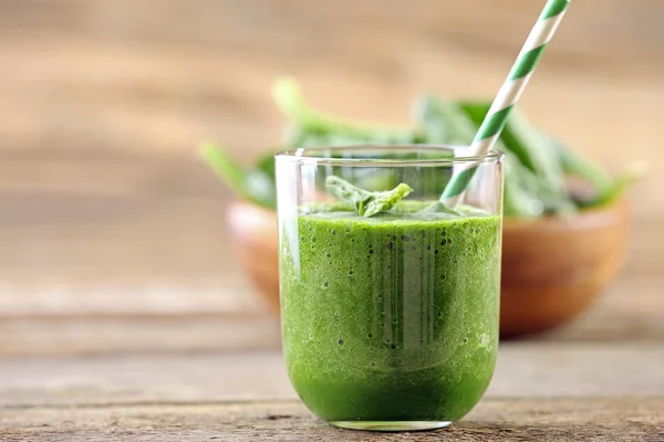 Verre de jus d'épinards sur fond en bois — Photo