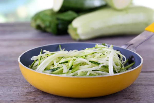 Grated zucchini and squash in pan on wooden table close up — Stock Photo, Image