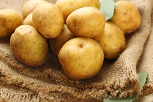 Batatas jovens em pano de saco de perto — Fotografia de Stock
