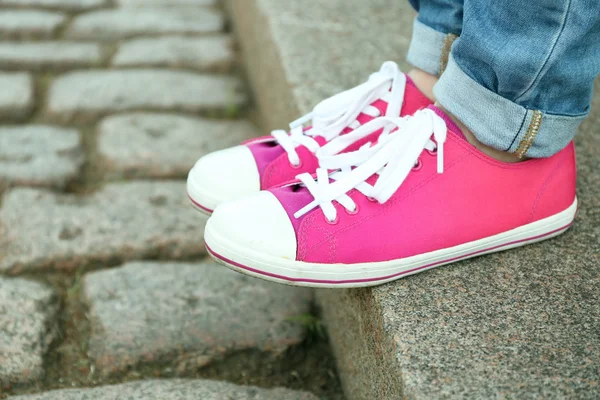 Pies femeninos en zapatos de goma rosa en escaleras de piedra — Foto de Stock