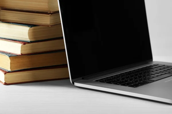 Stapel boeken met laptop op tafel close-up — Stockfoto