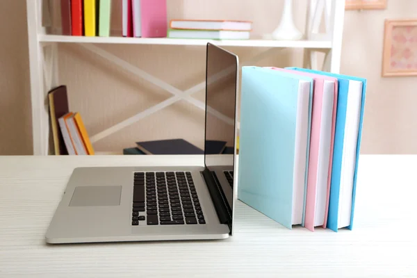 Stack of books with laptop on table in room — Stock Photo, Image