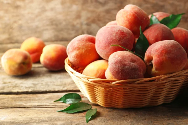 木制底座篮子里的成熟桃子 — 图库照片
