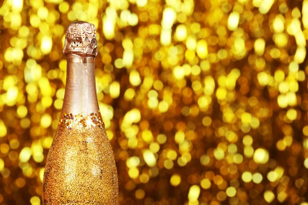 Украшенная бутылка шампанского на ярком размытом фоне — стоковое фото