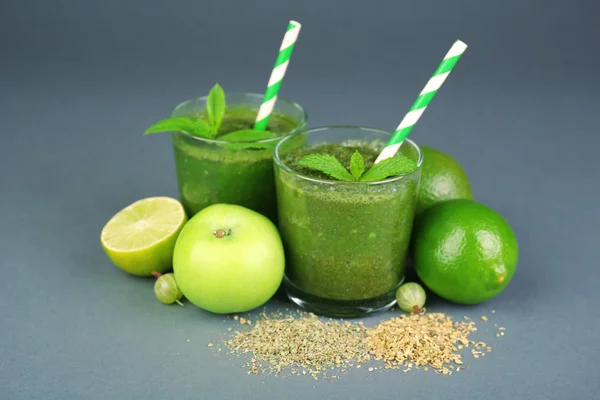 Groene gezond vruchtensap met fruit en specerijen op de grijze achtergrond — Stockfoto