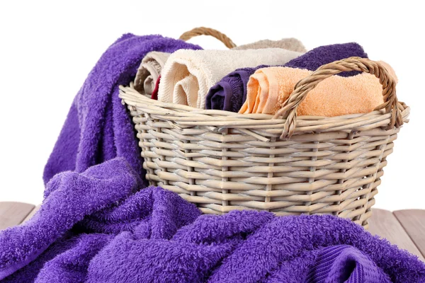 Colorful towels in basket on light background — Stock Photo, Image