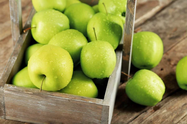 Zralé zelené jablko v bedně na dřevěný stůl zblízka — Stock fotografie