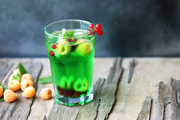 Glas koud verfrissend zomerdrankje met bessen en ijsblokjes op tafel close-up — Stockfoto