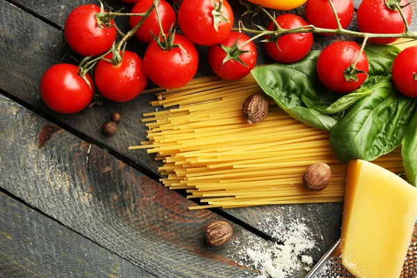 Makarna spagetti domates, peynir ve fesleğen rustik ahşap zemin üzerine — Stok fotoğraf