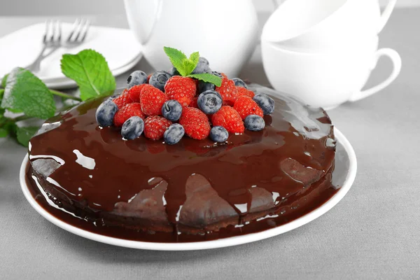 Вкусный шоколадный торт с летними ягодами на серой скатерти, крупным планом — стоковое фото