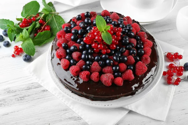 Deliziosa torta al cioccolato con bacche estive su tavolo di legno, primo piano — Foto Stock