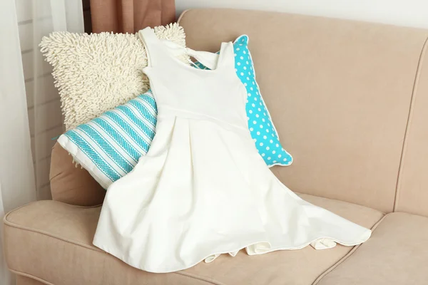 White female dress on sofa in room — Φωτογραφία Αρχείου