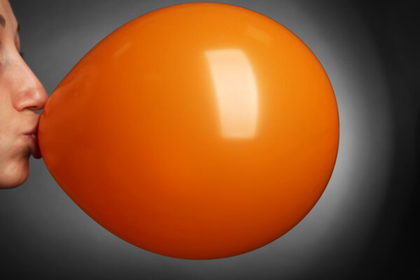 Young woman inflating balloon