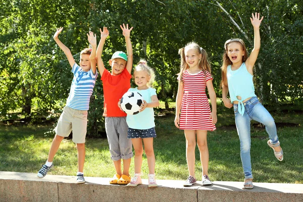 Happy active children playing with football in park — Stock Photo, Image