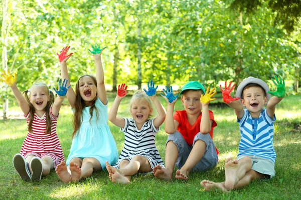 Happy active children with bright colored palms in park — Stock Photo, Image