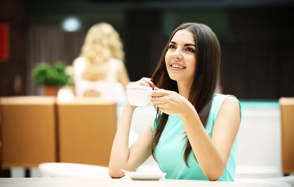 Bella giovane donna bere caffè in caffè — Foto Stock