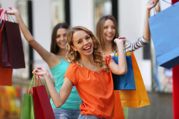 Belles jeunes femmes avec des sacs à provisions dans la rue de la ville — Photo