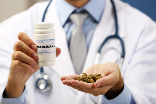 Doctor sosteniendo botella con cannabis medicinal de cerca — Foto de Stock