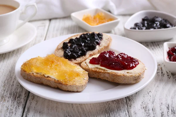 Fresh toast with butter and different jams on table close up — Stock Photo, Image