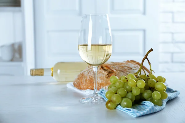 Still life of wine, grape and bread on light background