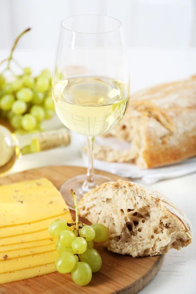 Still life of wine, grape, cheese and bread on light background — Stock Photo, Image