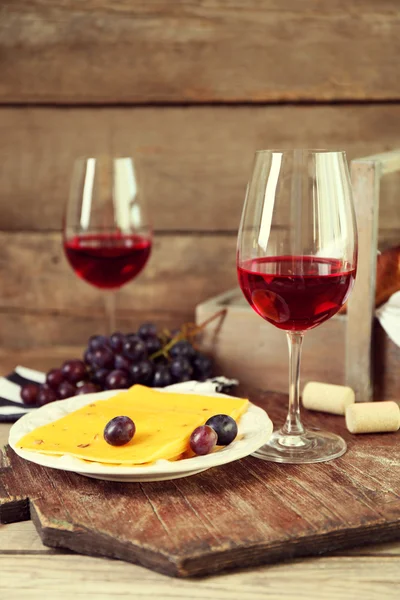 Still life of wine, grape, cheese and bread on rustic wooden background — Stock Photo, Image