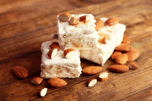 Sweet nougat with almonds on wooden background — Stock Photo, Image