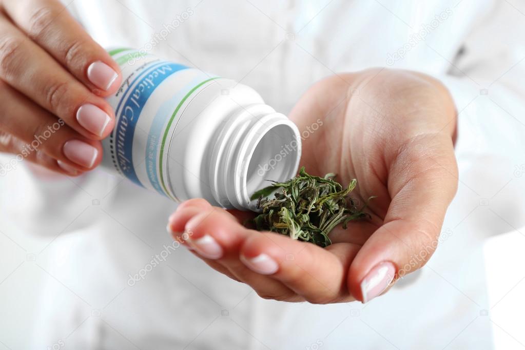 Doctor holding bottle of medical cannabis  
