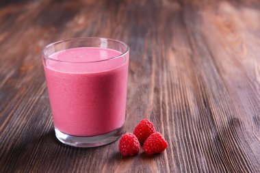 Ahşap arka plan üzerinde çilek ile Ahududu milkshake bardak