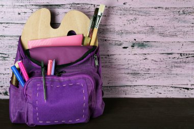 Ahşap arka plan üzerinde okul sırt çantası