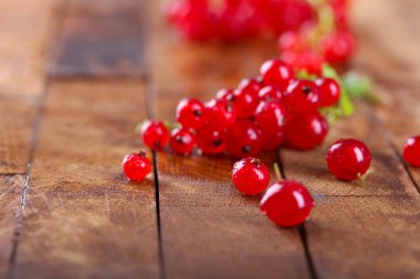 Ahşap masa üzerinde taze kırmızı kuş üzümü yakın çekim