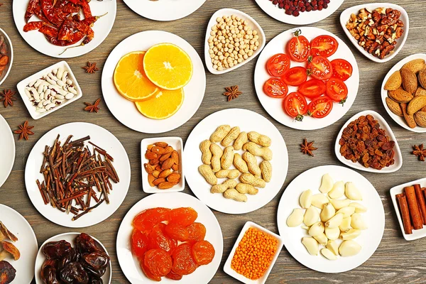 Different products on saucers on wooden table, top view — Stock Photo, Image