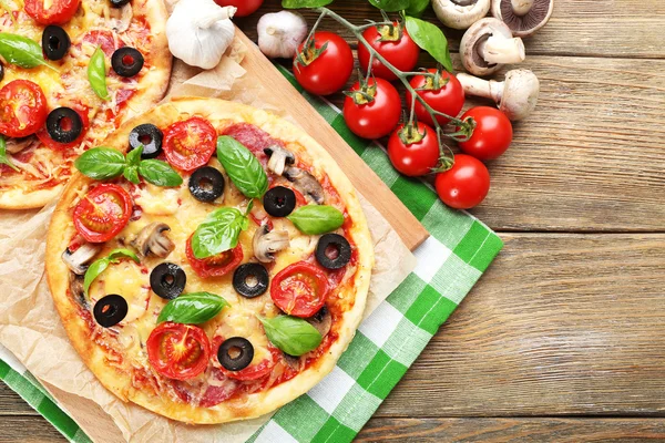 Pizza saborosa com legumes e manjericão na mesa de perto — Fotografia de Stock