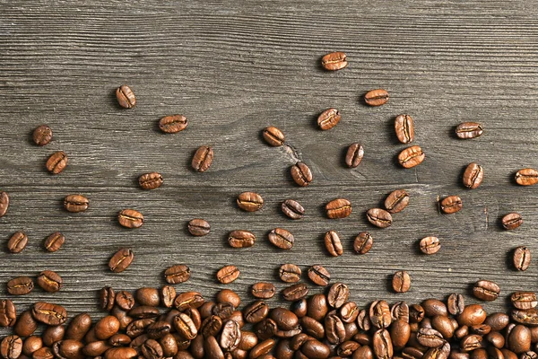 Grãos de café em fundo de madeira — Fotografia de Stock