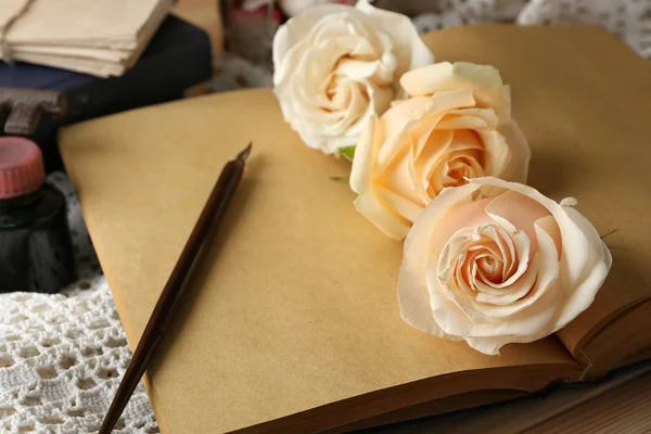 Rosas frescas con libro viejo, llave y letras sobre fondo de mesa de madera. Concepto Vintage —  Fotos de Stock
