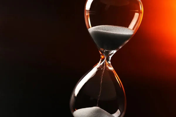 Hourglass on dark color background — Stock Photo, Image